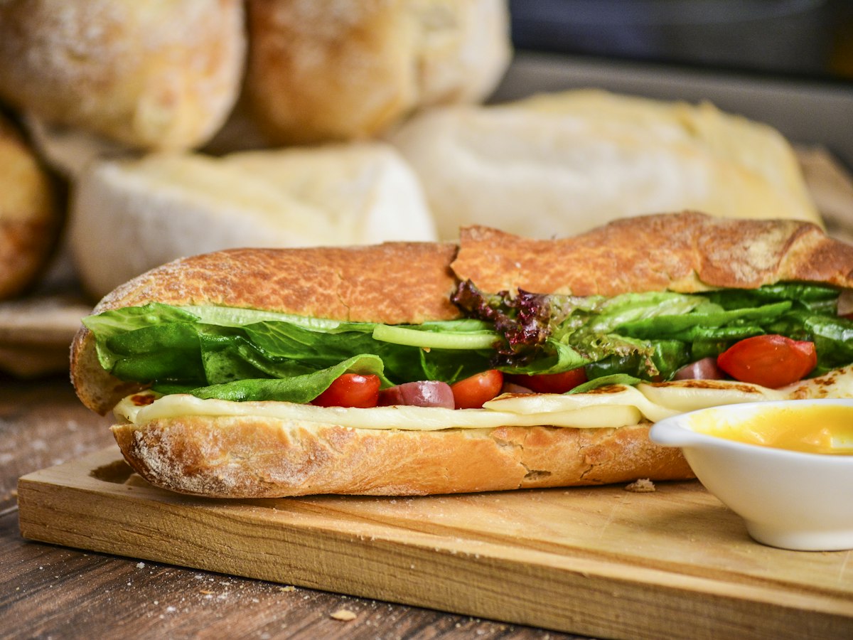 Sandwich sur baguette garni de fromage, de salade et de tomates