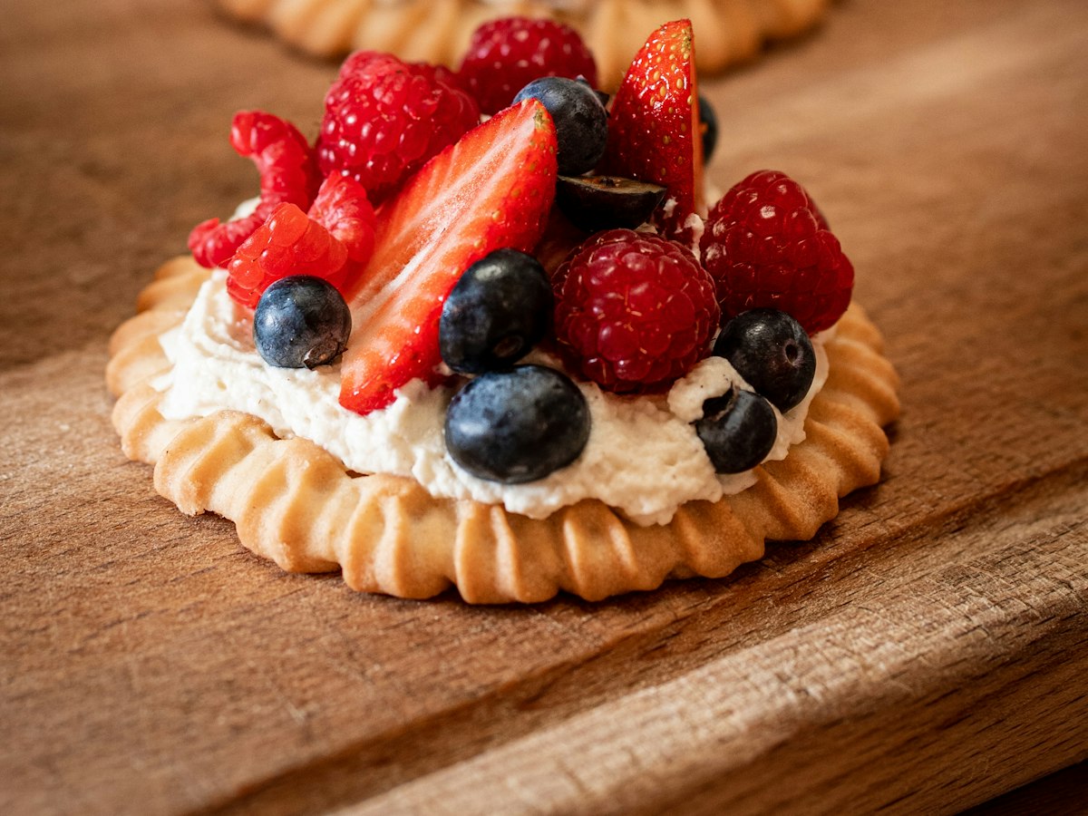 Tartelette garnie de crème, de framboises, de myrtilles et de fraises